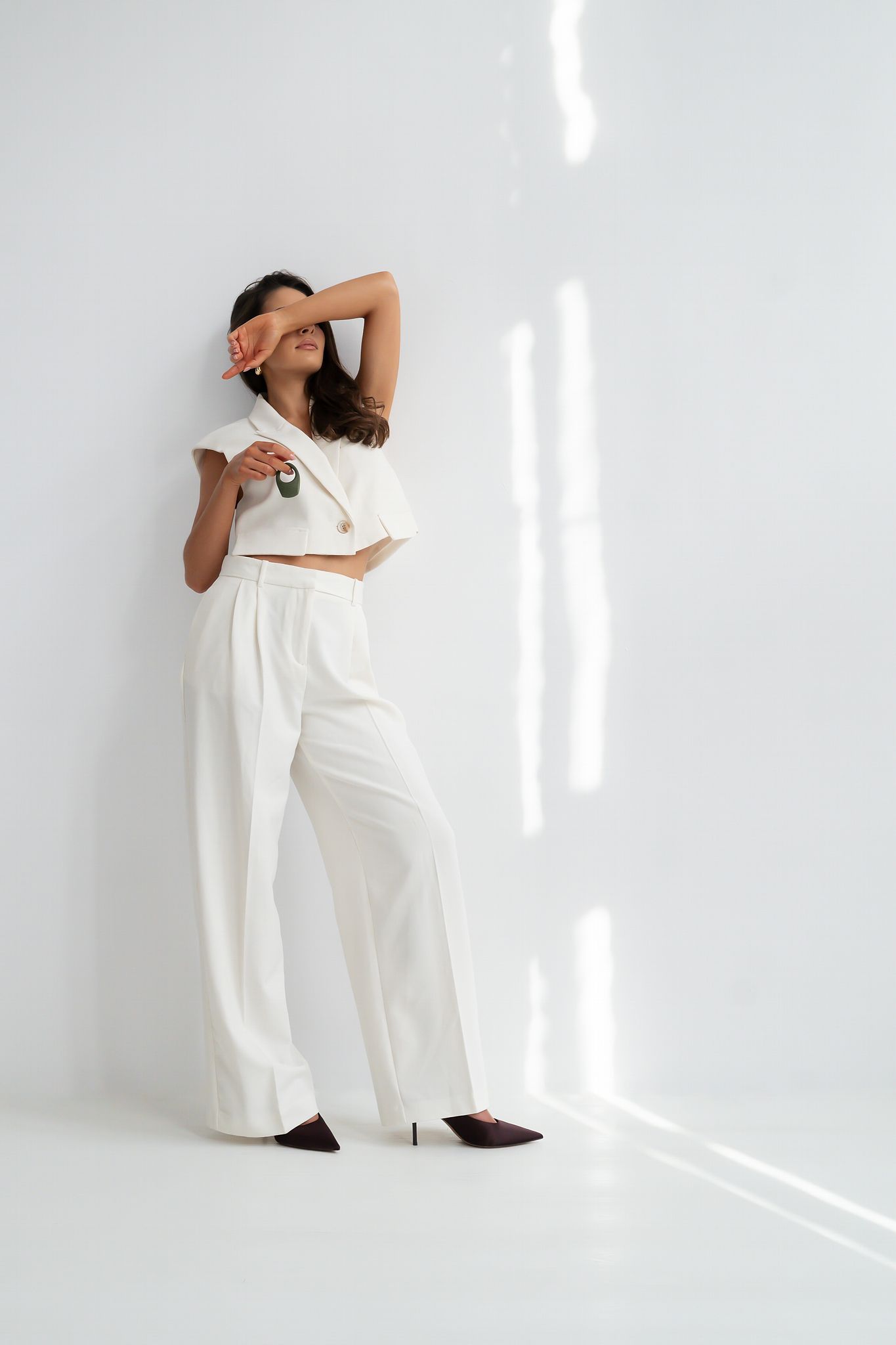 Terra - Naago. Minimalist vibrating ring held by model in relaxed setting, designed for intimacy and shared pleasure
