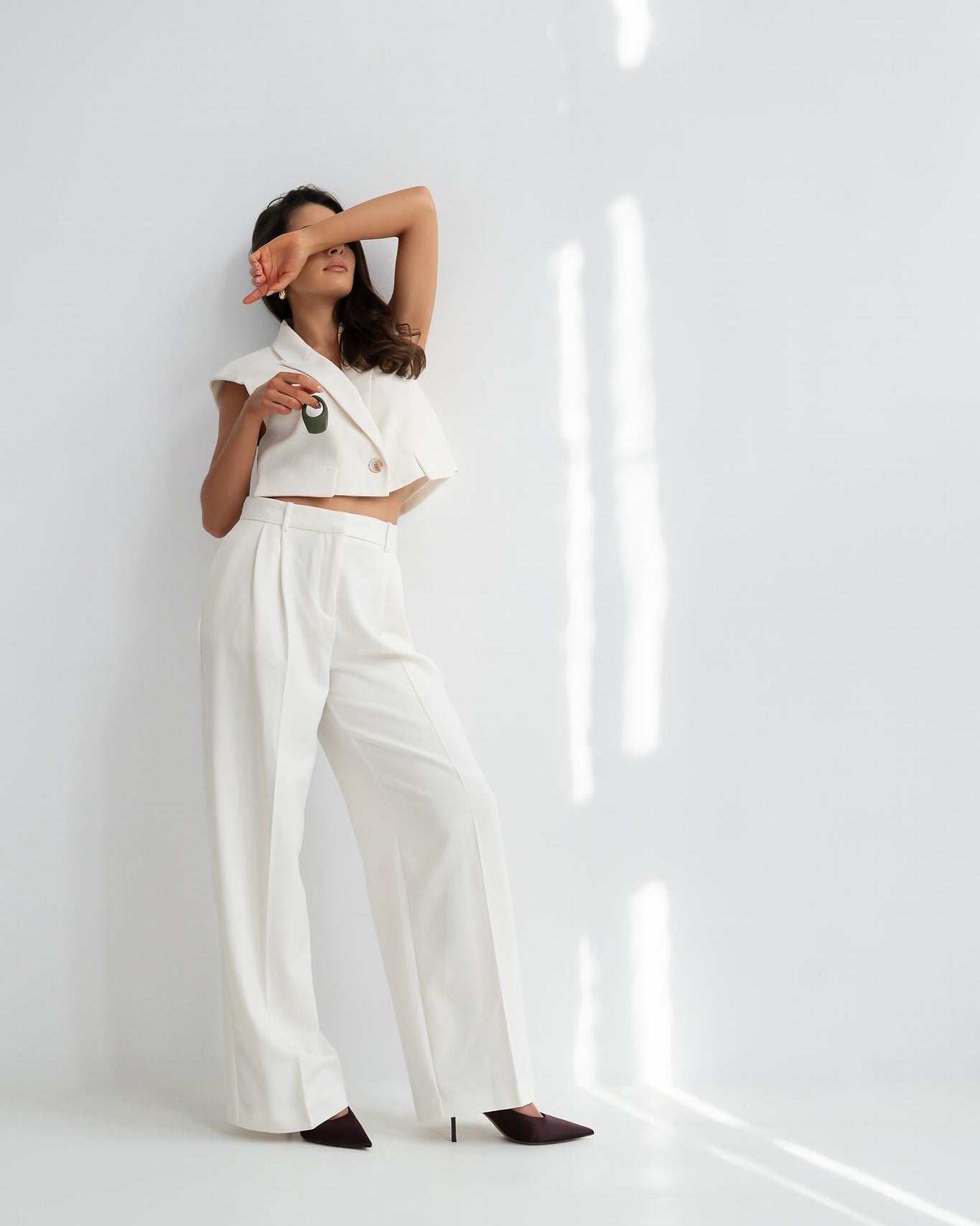 Terra - Naago. Minimalist vibrating ring held by model in relaxed setting, designed for intimacy and shared pleasure